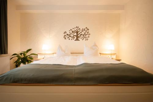 ein Schlafzimmer mit einem großen Bett mit zwei Kissen in der Unterkunft Brauers Landarthotel GmbH in Daun