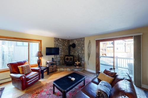 a living room with a leather couch and a fireplace at Quaint Mountain Condo in Frisco