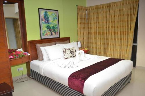 1 dormitorio con 1 cama grande con sábanas blancas en Lighthouse Family Retreat, en Cox's Bazar