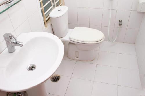 La salle de bains blanche est pourvue de toilettes et d'un lavabo. dans l'établissement Lighthouse Family Retreat, à Cox's Bazar