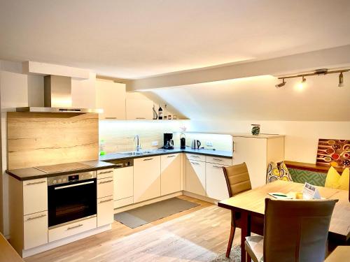 a kitchen with white cabinets and a table in a room at Appartement Maximilian in Tux