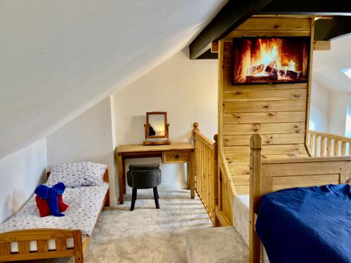 a bedroom with a bed and a desk with a tv at Garden Villa in Stafford