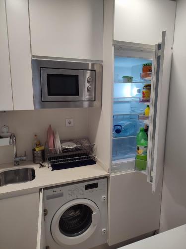 a kitchen with a washing machine and a refrigerator at CasaBarreiro in Barreiro