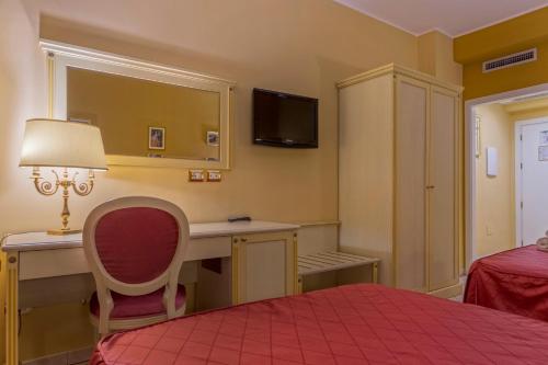 a bedroom with a desk and a bed with a lamp at Hotel San Michele in Milazzo