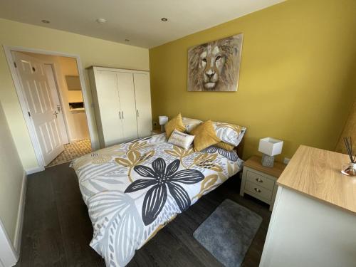 a bedroom with a bed with a painting on the wall at Orchard Cottage. in Lincoln