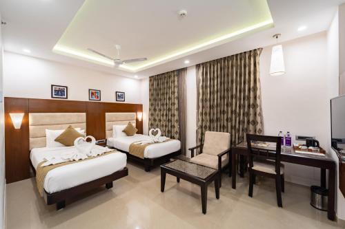 a hotel room with two beds and a desk at LA GRRANDE MALAR in Puducherry