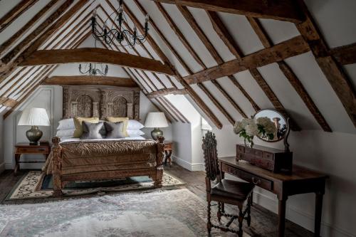 an attic bedroom with a bed and a desk at Chilston Park Hotel in Lenham