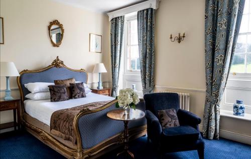 a bedroom with a bed and a chair at Chilston Park Hotel in Lenham