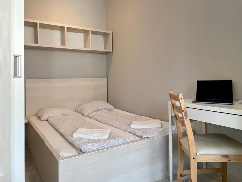 a bedroom with a bed with a desk and a computer at Stein in Bratislava
