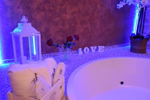 a bathroom with a bath tub with towels and flowers at SINFONIE PUGLIESI LUXURY ROOM in Turi