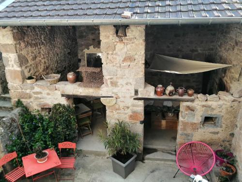 eine Außenterrasse mit einem Tisch, Stühlen und einem Sonnenschirm in der Unterkunft Maison in Dompierre-les-Ormes