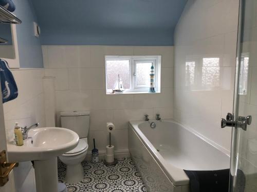 Bare Village Holiday Apartment في Bare: حمام مع حوض وحوض استحمام ومرحاض