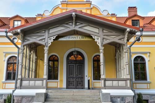 a yellow building with a black door at Schloss Fellin Boutique Hotel and Spa in Viljandi