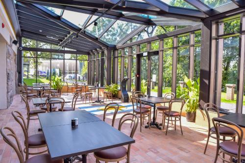 a restaurant with tables and chairs in a conservatory at Schloss Fellin Boutique Hotel and Spa in Viljandi
