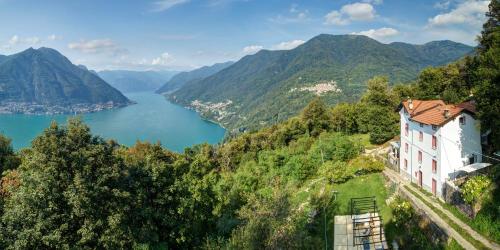 a house on a hill with a view of a lake at Essentia Guest House in Faggeto Lario 