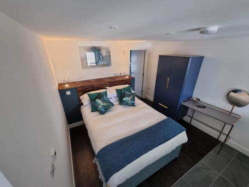 a small bedroom with a large bed with pillows at Chy Mor Apartment 1 in St Ives