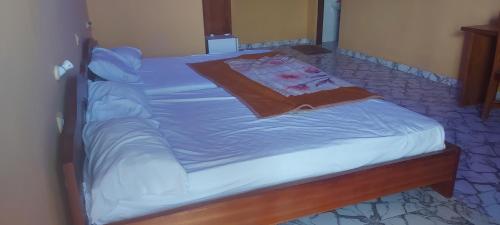 a bed with a blue comforter on top of it at IS Guest House in Cape Coast