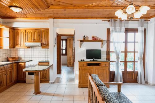 a kitchen with wooden cabinets and a tv and a table at Domus in Damouchari