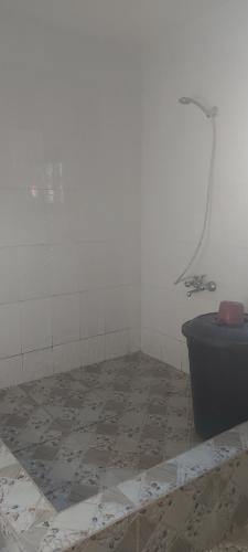 a bathroom with a blue toilet and a tiled floor at IS Guest House in Cape Coast