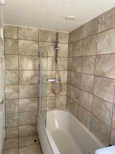 a bathroom with a tub and a shower at Large spacious 3 bedroom house Westerhope in Lemington