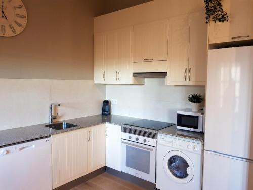a kitchen with white cabinets and a dishwasher at Cardona Fira in Cardona