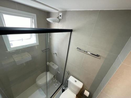 um banheiro com vaso sanitário e box de vidro em Bauten Cabo Branco - Flat uma quadra da praia em João Pessoa