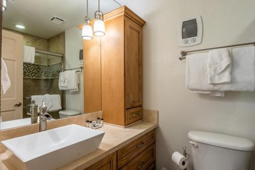 a bathroom with a sink and a toilet and a mirror at Mountainback 80 in Mammoth Lakes