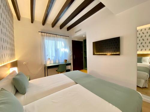 a bedroom with two beds and a desk at Alaró Natura Rural Suites in Alaró