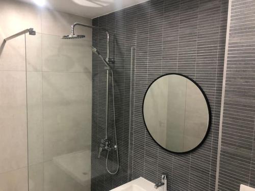 een badkamer met een spiegel, een douche en een wastafel bij Acogedor apartamento a 100 mtr de la playa, in Oropesa del Mar