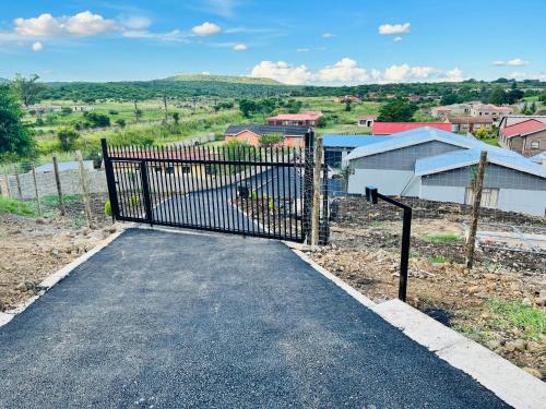 a gate to a driveway with a house at Aaron's Nest Bed and Breakfast in Ladysmith
