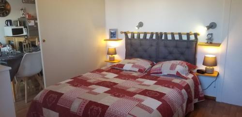 una camera con un letto con una trapunta rossa e bianca. di Au Centre de la station de ski de Valfréjus - appartement 4-6 personnes a Valfréjus