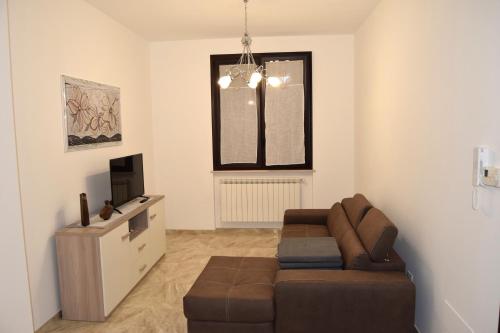 ein Wohnzimmer mit einem Sofa und einem TV in der Unterkunft Casa D'Amico in Arnesano