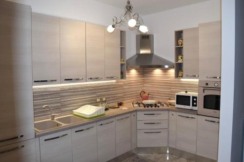 una cocina con armarios blancos y fregadero en Casa D'Amico, en Arnesano