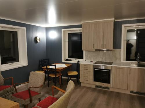 eine Küche und ein Esszimmer mit einem Tisch und Stühlen in der Unterkunft NyksundRom, Nyksund in Nyksund