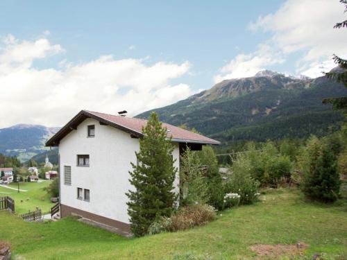a house in a field with mountains in the background at Modern Chalet in Piller near Ski Area in Wenns
