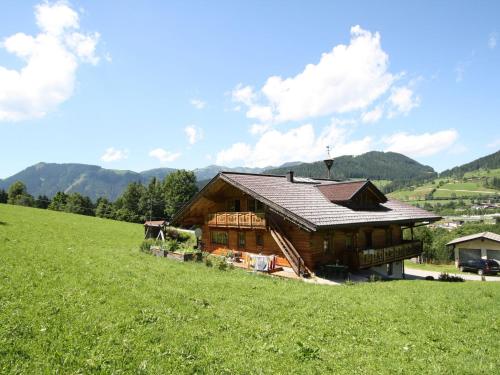 a large wooden house on a hill with a green field at Villa on a courtyard near the ski area in Salzburg in Eben im Pongau