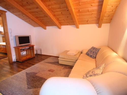 a living room with a couch and a tv at Villa on a courtyard near the ski area in Salzburg in Eben im Pongau