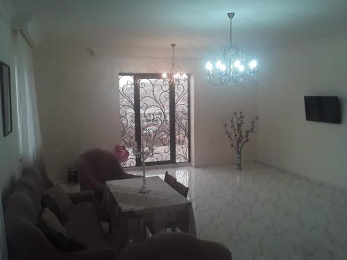 a living room with a door with a chandelier and a table at ABO in Yerevan
