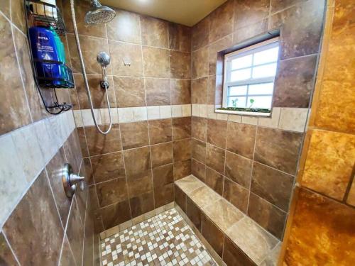 a bathroom with a shower with a tiled shower at The Greenhouse - 3bed 2bath home in Tahlequah, OK in Tahlequah