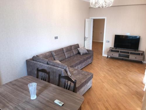 ein Wohnzimmer mit einem Sofa und einem Tisch in der Unterkunft Family Apartment in Baku