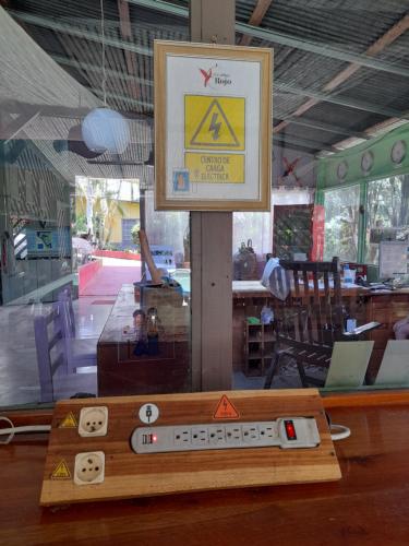 a remote control sitting on top of a wooden table at Hotel El Colibri Rojo - Cabinas - Le Colibri Rouge in Cahuita