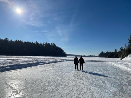 two people walking on a snow covered road at Pourvoirie du Lac Blanc in Saint-Alexis-des-Monts