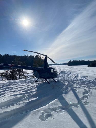 a small helicopter parked in a snow covered field at Pourvoirie du Lac Blanc in Saint-Alexis-des-Monts
