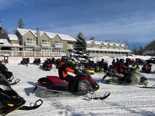 a group of people riding on snowmobiles in the snow at Pourvoirie du Lac Blanc in Saint-Alexis-des-Monts