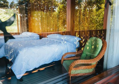 - une chambre avec un lit, deux chaises et une fenêtre dans l'établissement Hotel Heliconia - Monteverde, à Monteverde Costa Rica