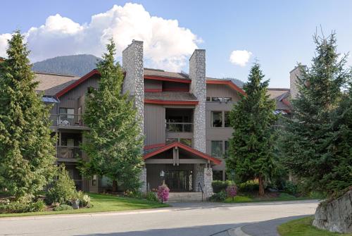 un gran edificio con árboles frente a una carretera en Greyhawk by Whistler Premier, en Whistler