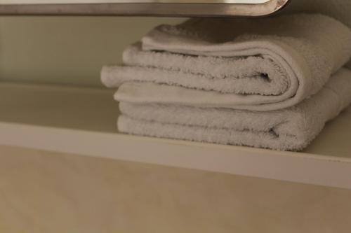 a stack of towels on a shelf in a bathroom at Mössebergs vandrarhem in Falköping