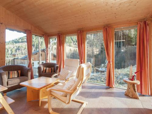 uma sala de estar com uma mesa, cadeiras e janelas em Chalet in Stadl an der Mur with sauna em Stadl an der Mur