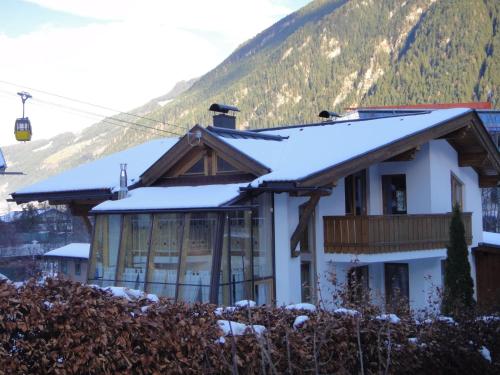 una casa en las montañas con nieve en el techo en Lovely Chalet in Mayrhofen with Private Garden, en Mayrhofen