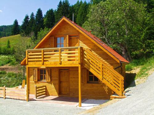 LiebenfelsにあるHoliday apartment in a wooden chalet in Liebenfels Carinthia near the ski areaのポーチとバルコニー付きのログキャビン
